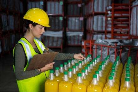 female-worker-examining-juice-bottles